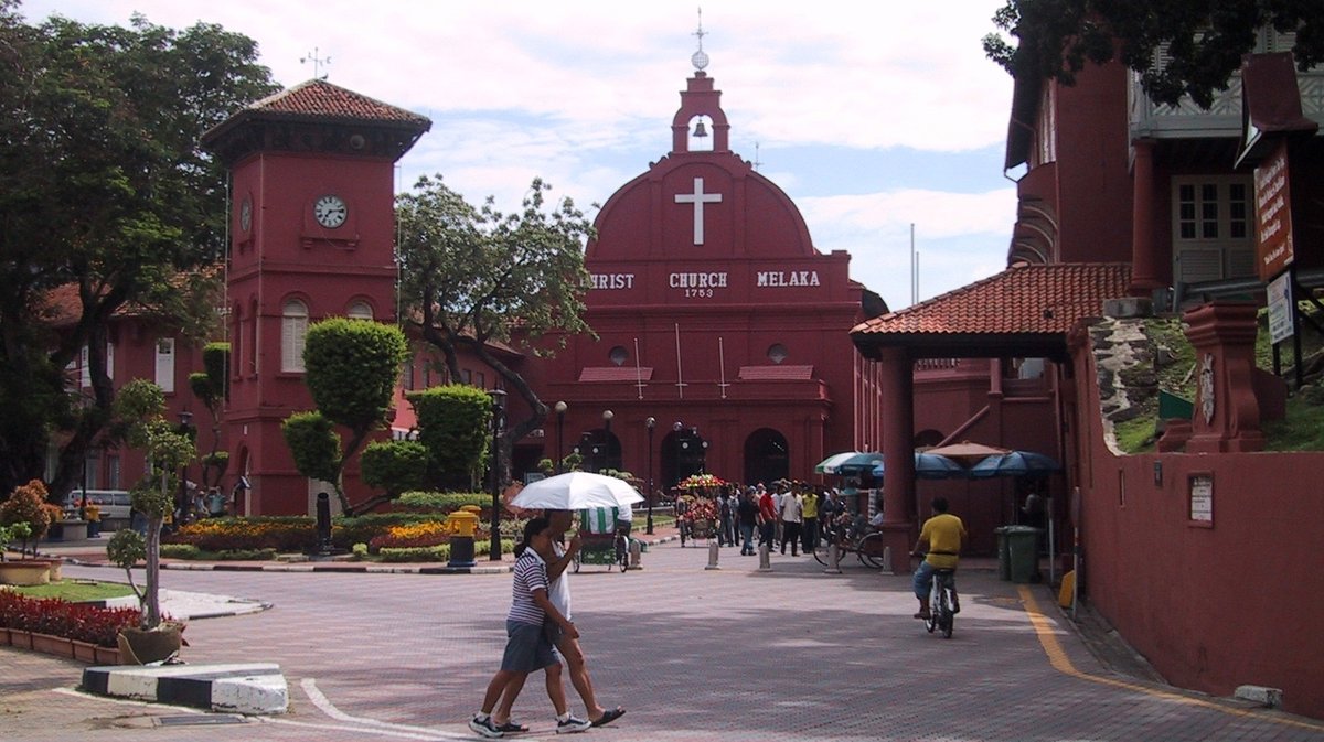 Historical church building in Melaka with clock tower under blue sky