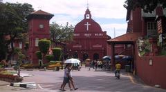 Historical church building in Melaka with clock tower under blue sky