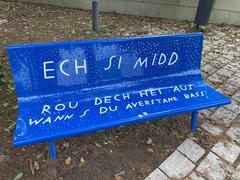 Blue bench near MUDAM with inscription in Luxembourgish