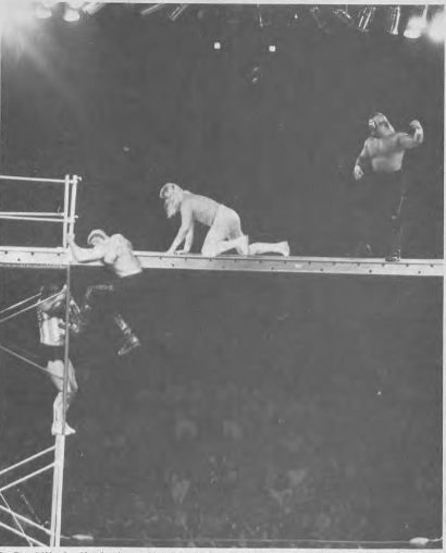 Scaffold match at Starrcade '86 showing Road Warrior Hawk kicking Dennis Condrey while Road Warrior Animal approaches Bobby Eaton on November 27, 1986