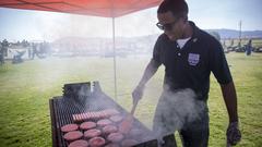 US Marine volunteer grilling hamburgers and hot dogs at homecoming event