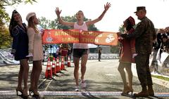 Andrew Dumm winning the 2008 U.S. Marine Corps Marathon under a banner held by Marine Corps Commandant and USO American Bells