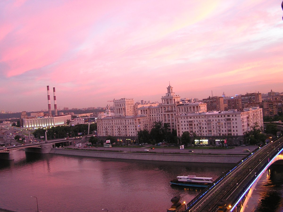 Summer sunset view of Taras Shevchenko embankment with serene river and cityscape