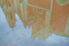 Reflection of St. Catherine's Church in a puddle on a paved area in Vilnius