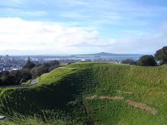 Aerial view of Mt Eden crater with green vegetation and surrounding urban area in Auckland