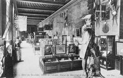 Historical postcard photograph of a room in the Army Museum circa 1900 featuring the statue of Marshal de Rochambeau in the foreground