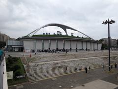 A scenic view of Komazawa Olympic Park with lush green trees and walking paths under a clear sky