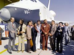 The Shuttle Enterprise rolls out of Palmdale manufacturing facilities with Star Trek cast members including DeForest Kelley, George Takei, James Doohan, Nichelle Nichols, Leonard Nimoy, Gene Roddenberry, and others