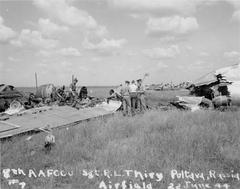 American officers among the wreckage of a B-17 bomber destroyed by a German bombing raid at an airfield near Poltava
