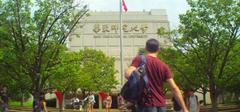 Glenn Duffie Shriver standing at the main entrance of East China Normal University in Shanghai