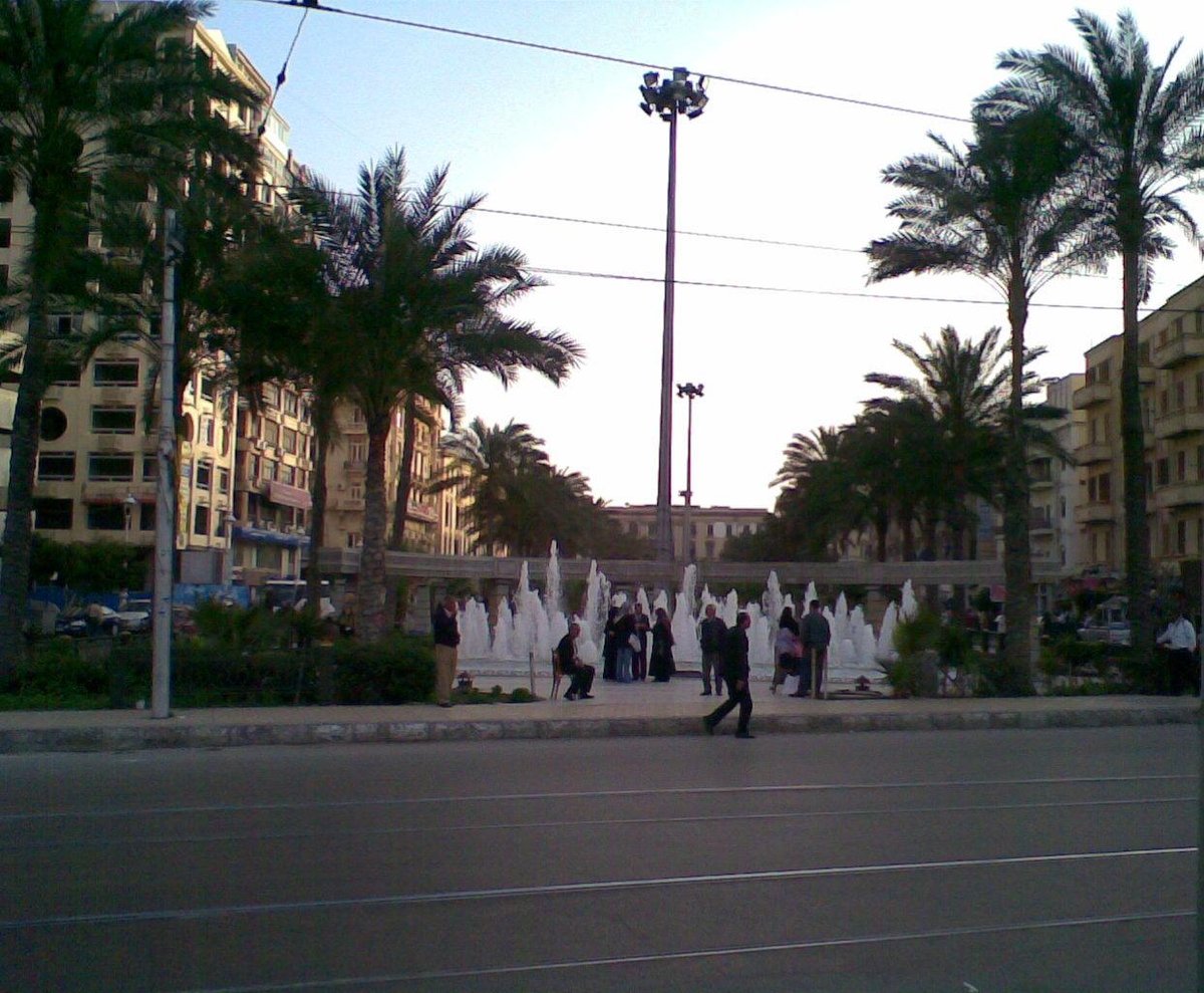 Ahmed Orabi Square in El Manshiya Alexandria Egypt with historic buildings and palm trees