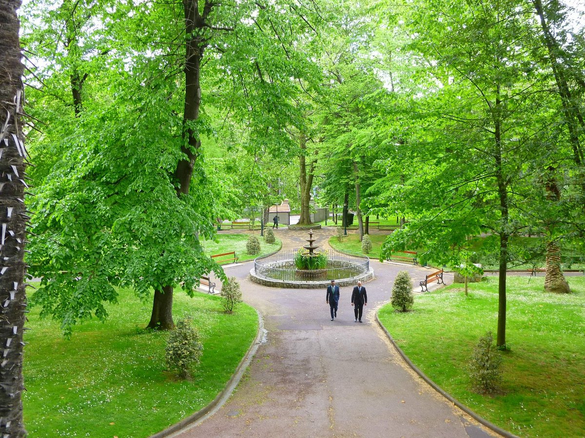 Jardines de la Santa y Real Casa de la Misercordia gardens in Bilbao with green trees and historic building