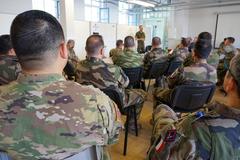 Military personnel conducting Joint Air-Ground Integration Center (JAGIC) training with digital airspace plans in Lille, France