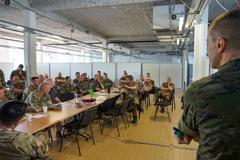 Multinational military personnel conducting joint air-ground integration training in Lille, France, working on airspace plans during day 2 of the 19th Battlefield Coordination Detachment JAGIC exercise