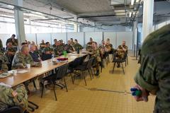 Military personnel conducting joint air-ground integration training with maps and communication equipment