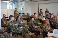 Military personnel participating in JAGIC training building unit airspace plans for multinational joint operations