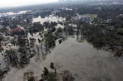 Aerial view of flooded New Orleans neighborhood with city skyline in background during Hurricane Katrina evacuation