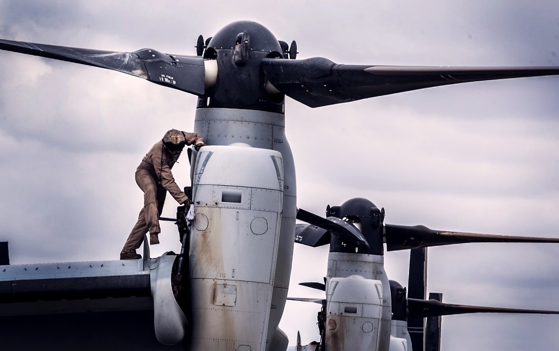 Marine wiping down MV-22B Osprey aircraft after drills in Kenya