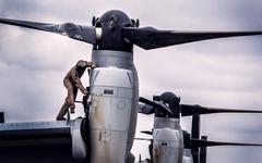 Marine wiping down MV-22B Osprey aircraft after drills in Kenya