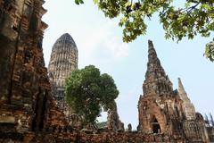 Wat Chai Watthanaram temple enclosure wall with headless Buddha statues and large central prang