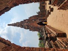 Headless Buddha statues surrounding cloister gallery with stupa-shaped chapel in Wat Chai Watthanaram temple