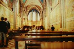 Exterior view of Basilica di San Francesco in Assisi with stone facade and rose window