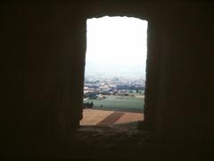 Scenic Assisi countryside view from the Basilica with lush greenery and gentle hills under a blue sky