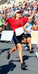 Lt. Katy Pekala nearing finish line at Panathenaic Olympic Stadium during 41st Athens Authentic Marathon 2024 carrying olive branch gifted by child
