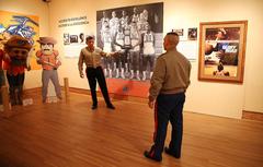 Major General Juan G. Ayala visiting Centennial Museum and Gardens at University of Texas at El Paso pointing at 1966 NCAA Basketball Champions photo