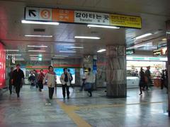 Interior view of Express Bus Terminal Station with escalators and people