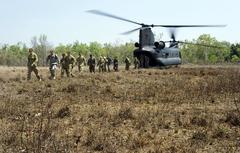 U.S., Australian and Chinese service members disembarking from an Australian Army CH-47 Chinook helicopter in Northern Territory Australia during survival training