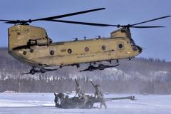 U.S. soldiers in cold Alaska preparing 155mm howitzer for CH-47 Chinook helicopter flight