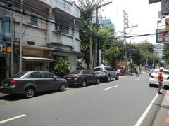 Busy street intersection at United Nations Avenue and M. H. del Pilar Street in Ermita, Manila with vehicles, pedestrians, and the Carlos P. Romulo Monument