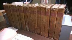 Several volumes of the 18th century French encyclopedia Description des arts et métiers with some open on a table