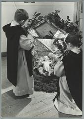 Two boys in religious robes by the nativity scene at Christmas in Benedictine abbey school of Sint Andries in Lophem near Bruges Belgium 1935