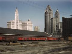 Trucks unloading at Illinois Central Railroad South Water Street freight terminal Chicago with Wrigley Building and Tribune Tower in background