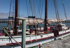 Woman mopping the deck of the boat Alma during volunteer maintenance