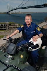 Coast Guard Petty Officer 1st Class Harry Wong sitting on an all-terrain vehicle at Fort Wadsworth Staten Island