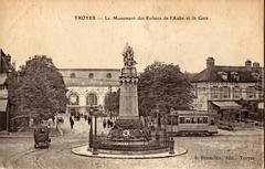Old postcard showing the Monument des Enfants de l'Aube and Troyes train station with an electric tram engine