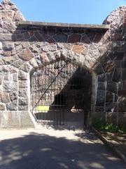 Old abandoned bear cage in Korkeasaari Zoo with rusty metal bars and concrete surroundings