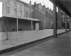 Black and white photo of the Jewish Amsterdamers memorial - De Aula, featuring the eternal flame monument