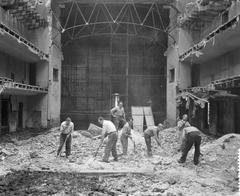 Interior of the Hollandse Schouwburg being arranged as a memorial site with preparations for a grassy lawn in the main hall