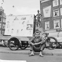 Jasper Grootveld waiting on city street with drawings on cargo bike in Amsterdam 1964