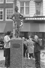 Black and white photograph of the Lieverdje statue being re-erected at Spui with sculptor Kneulman present, taken on October 10, 1972