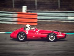 Formula 1 cars racing at Brno Grand Prix circuit during a sunny day