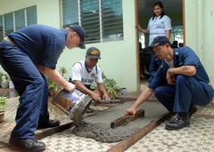 U.S. Navy Chief Petty Officer Randy Bell, Senior Chief Petty Officer Albert Puyot, and Philippine navy sailor working on school construction in Cavite, Philippines