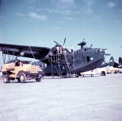 Crewman performing 60-hour check on Pratt & Whitney R-2800 engine of Martin PBM-5 Mariner patrol plane at Naval Station Sangley Point Philippines 1953