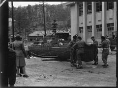 World War II soldiers inspecting damaged model of Japanese battleship at naval academy on Eta Jima