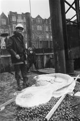 Black and white photo of BBK members demonstrating with incendiary devices and signs at the first pile driving ceremony for Rijksmuseum Vincent van Gogh in Amsterdam, November 1969