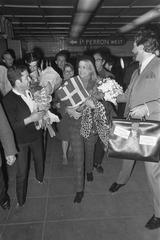 Melina Mercouri arriving at Amsterdam Central Station wearing a beret and holding a Greek flag in 1968